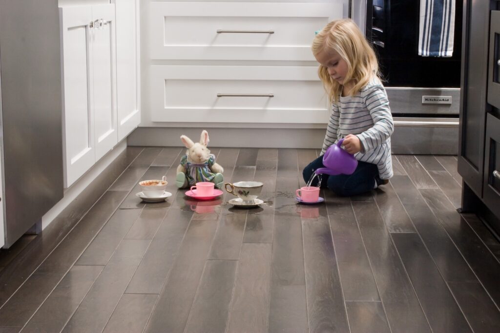 girl playing on kitchen floor | Dolphin Carpet & Tile