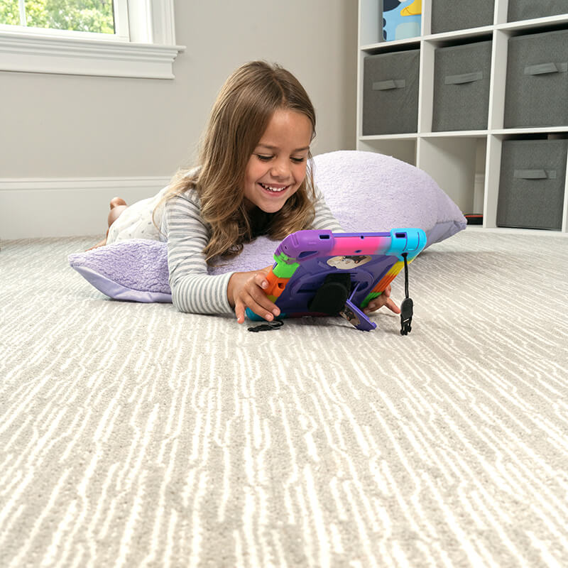 Kid laying on carpet playing on tablet | Dolphin Carpet