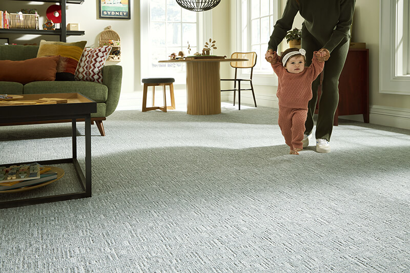 Toddler walking with parent on carpet