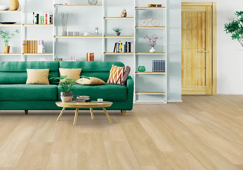 Light color laminate flooring in room light colored room with green couch