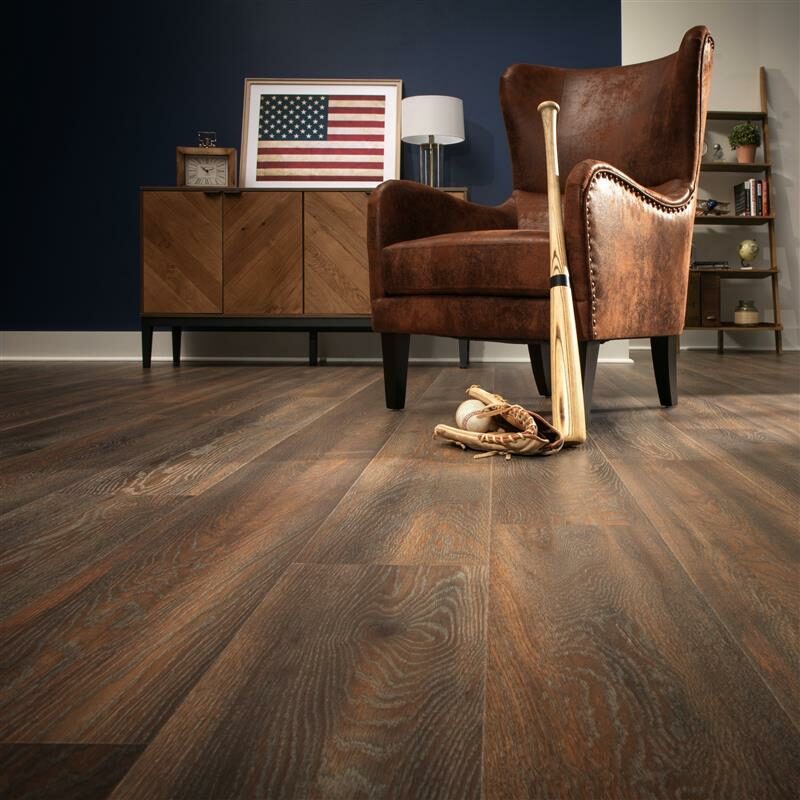 Laminate flooring in living space with baseball bat and glove laying about.